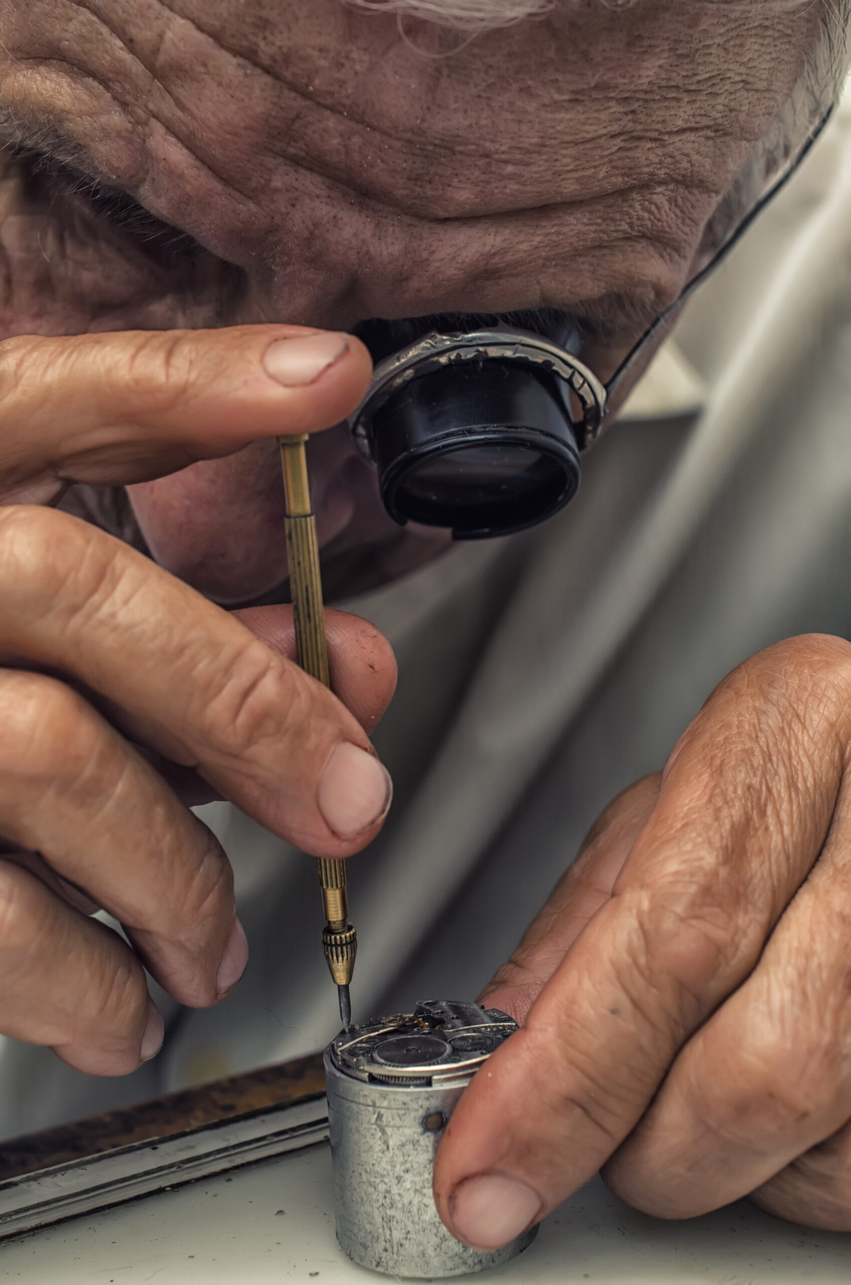 L'horloger entrain de réparer une montre avec une précision chirurgicale. Nos valeurs d'authenticité et d'élégance se retrouvent dans son métier