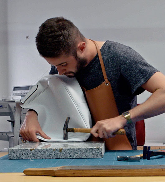 Le maroquinier faisant son travail de précision. Nos valeurs se retrouvent dans son métier.